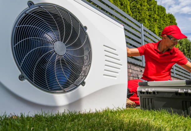 Professional HVAC Worker in His 40s Installing Swimming Pool Heat Pump Outdoor Water Heating Device. Energy Saving Technologies.